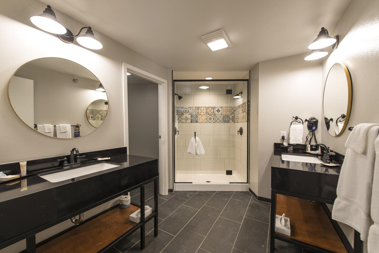 A view of a very large bathroom in the King Deluxe Suite including a large walk-in shower and two vanity areas